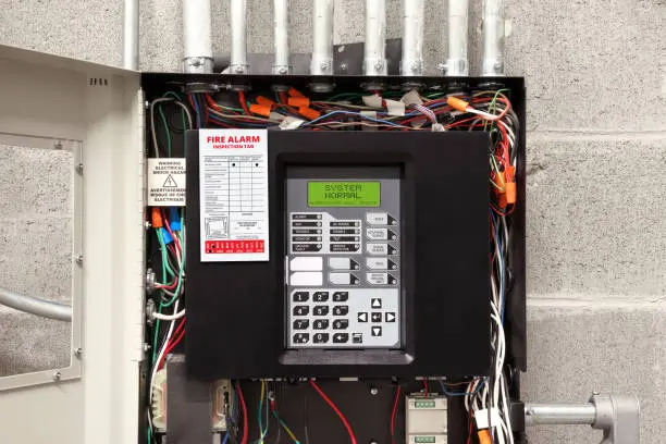 Open cabinet of single-stage fire alarm system in strata, residential or commercial building. System running normal. Selective focus.